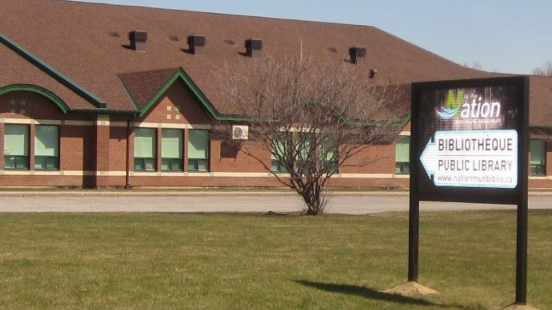 Limoges branch library with a brown roof and a sign on a grassy lawn.