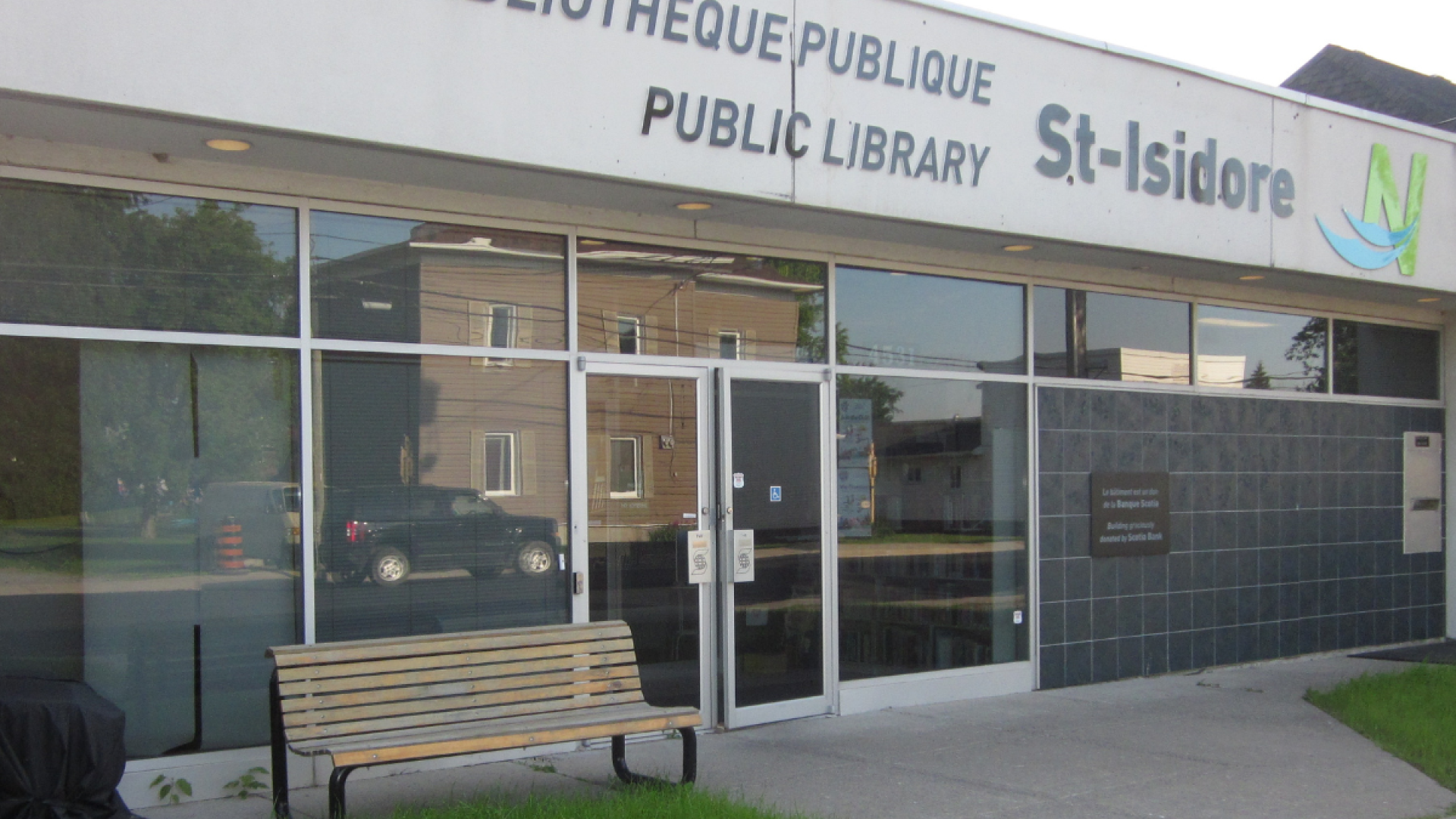 St-Isidore Public Library exterior with a bench and glass entrance.