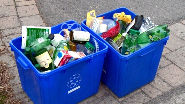 Deux bacs bleus remplis d'items recyclables