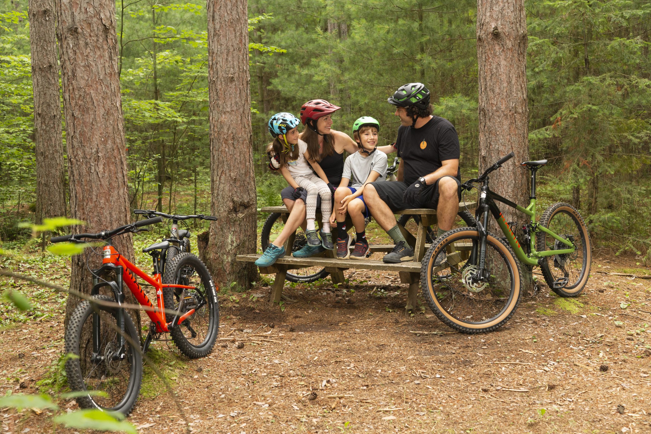Jeune famille de cyclistes assis à une table de picnic